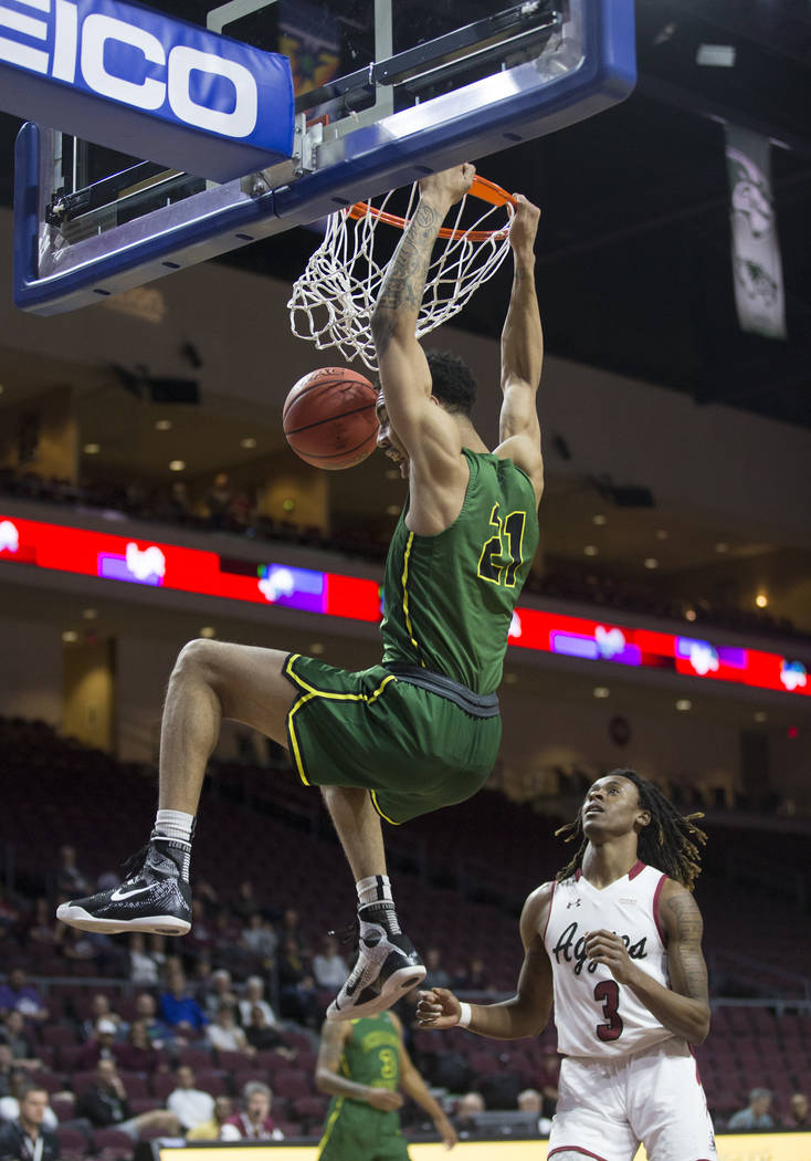 Chicago State sophomore forward Cameron Bowles (21) dunks over New Mexico State junior guard Terrell Brown (3) in the first half of the opening round of the Western Athletic Conference tournament ...