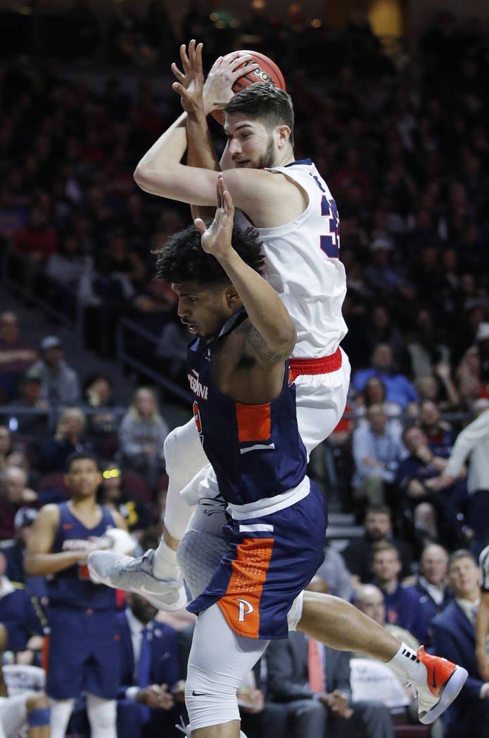 Pepperdine's Darnell Dunn, bottom, fouls Gonzaga's Killian Tillie, top, during the second half of an NCAA semifinal college basketball game at the West Coast Conference tournament, Monday, March 1 ...