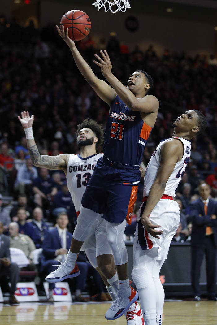Pepperdine's Eric Cooper Jr. (21) shoots around Gonzaga's Zach Norvell Jr., right, and Josh Perkins during the second half of an NCAA semifinal college basketball game at the West Coast Conference ...