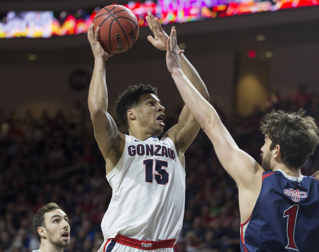 Gonzaga junior forward Brandon Clarke (15) drives past St. Mary's senior center Jordan Hunter (1) in the first half during the West Coast Conference finals game on Tuesday, March 12, 2019, at Orle ...