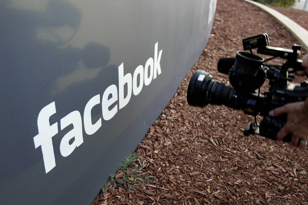 In this file photo a television photographer shoots the sign outside of Facebook headquarters in Menlo Park, Calif. (AP Photo/Paul Sakuma)