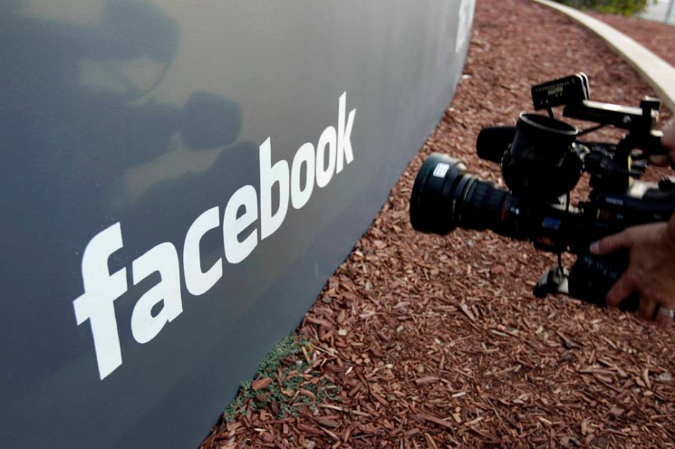 In this file photo a television photographer shoots the sign outside of Facebook headquarters in Menlo Park, Calif. (AP Photo/Paul Sakuma)