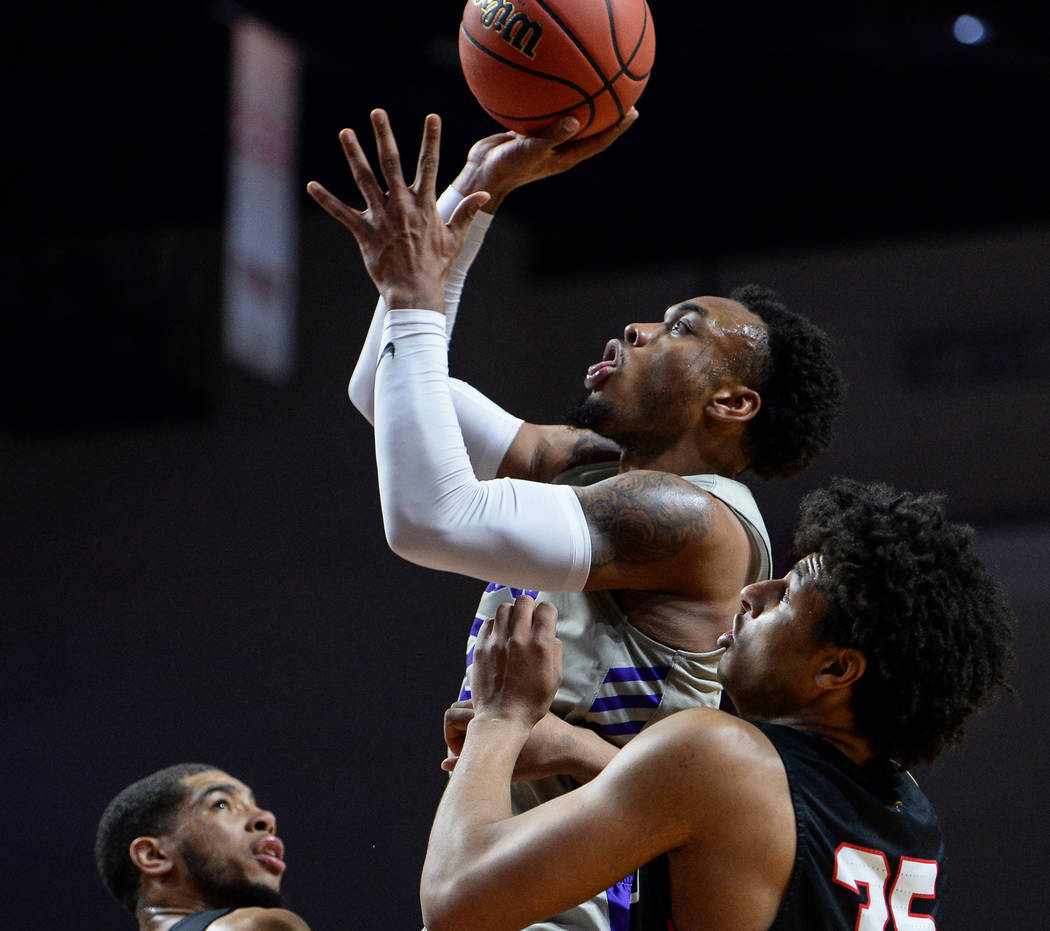 Grand Canyon guard Carlos Johnson (23) jumps up to take a shot while being guarded by Seattle guard/forward Riley Grigsby (35) in the first half of the opening round of the Western Athletic Confer ...