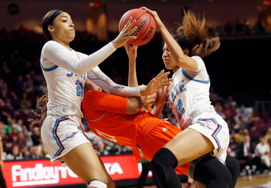 New Mexico State guard Dominique Mills, left, and teammate Kalei Atkinson (22) go after a loose ball over Texas-Rio Grande Valley guard Quynne Huggins (11) during an NCAA college basketball game i ...