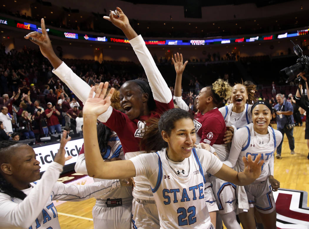 New Mexico State players celebrate after defeating Texas-Rio Grande Valley 76-73 in double overtime during a NCAA college basketball Western Athletic Conference Women's Tournament championship gam ...