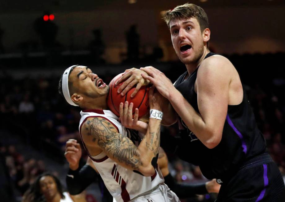 New Mexico State guard Trevelin Queen (20) and Grand Canyon's Alessandro Lever vie for a rebound during the first half of an NCAA college basketball game for the Western Athletic Conference men's ...