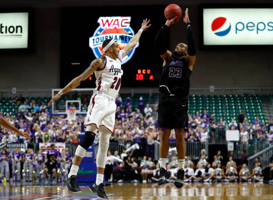 Grand Canyon's Carlos Johnson (23) shoots over New Mexico State guard Trevelin Queen (20) during an NCAA college basketball game for the Western Athletic Conference men's tournament championship S ...