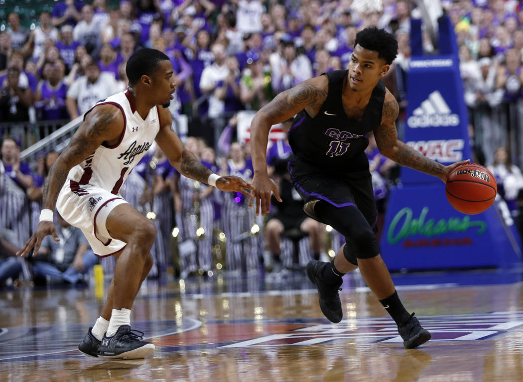 Grand Canyon's Damari Mislead (11) drives by New Mexico State guard AJ Harris (12) during the first half of an NCAA college basketball game for the Western Athletic Conference men's tournament cha ...