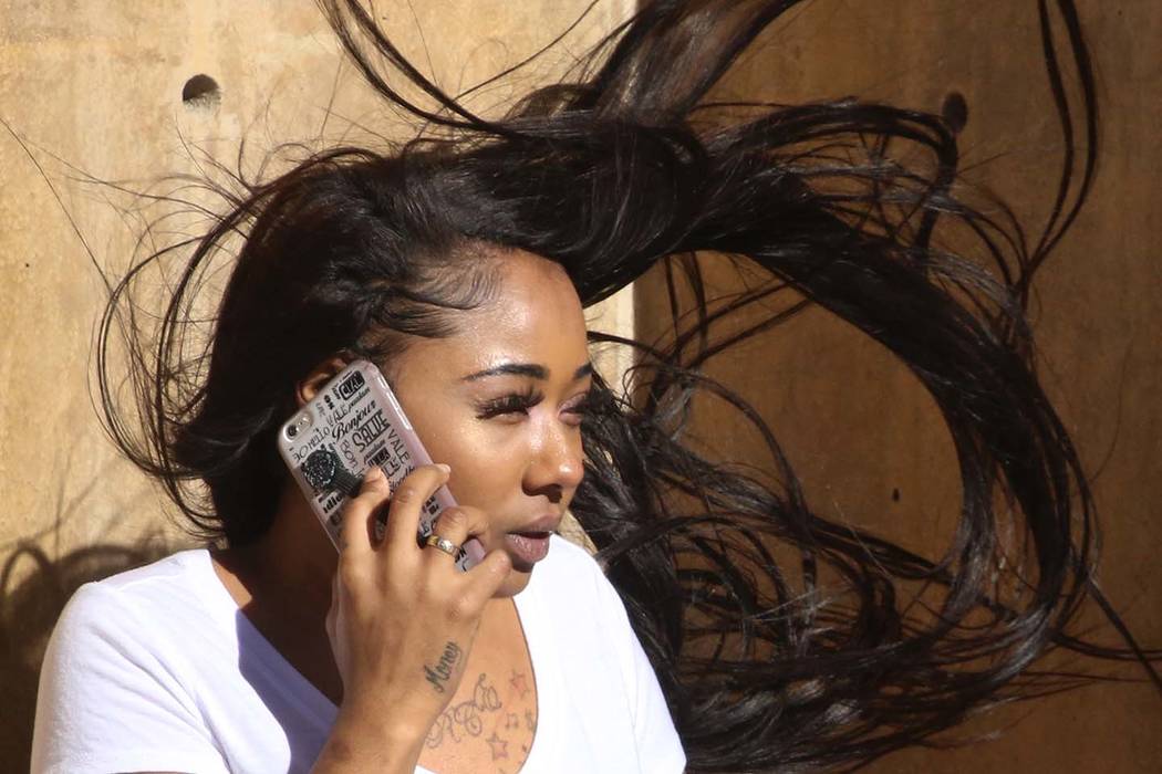 A woman has her hair blown by heavy wind as she talks on her phone on Third street on Wednesday, March. 13, 2019, in Las Vegas. Bizuayehu Tesfaye Las Vegas Review-Journal @bizutesfaye
