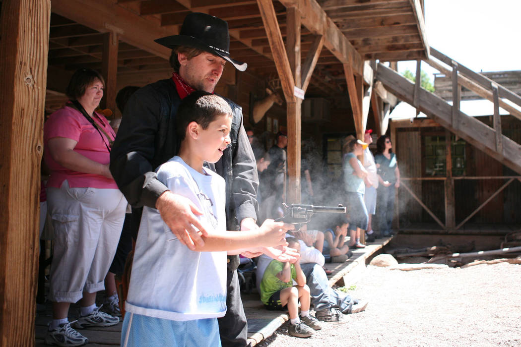 Former Las Vegas Review-Journal columnist Corey Levitan, left, teaches 9-year-old Lennon Walker how to use the .22 caliber prop gun at Bonnie Springs on April 28, 2007. (Las Vegas Review-Journal file)