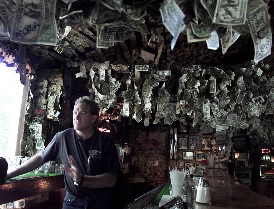 Alan Levinson stands behind the bar of the Bonnie Springs Ranch in 2001. The bar wall is covered with thousands of dollar bills left by visitors. The Levison family are going to take down the mone ...