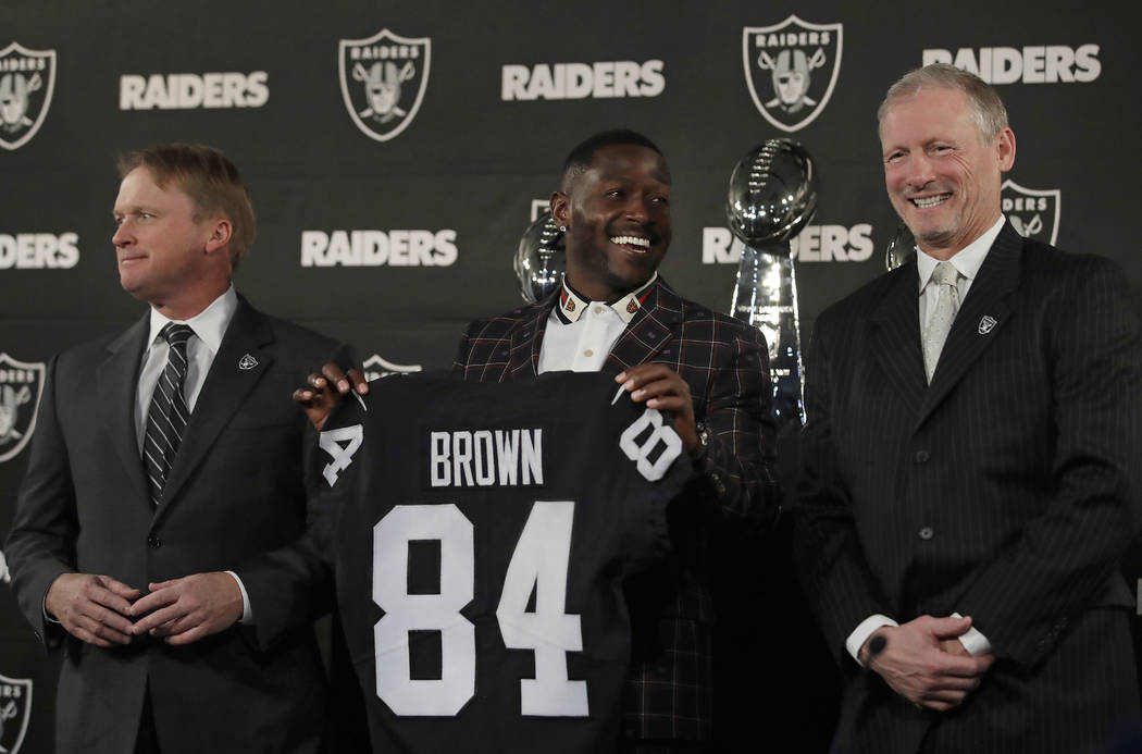 Oakland Raiders wide receiver Antonio Brown, center, holds his son Apollo beside coach Jon Gruden, left, after an NFL news conference Wednesday, March 13, 2019, in Alameda, Calif. (AP Photo/Ben Ma ...