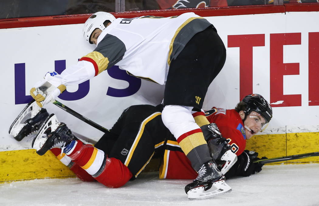 Vegas Golden Knights' Deryk Engelland, top, checks Calgary Flames' Matthew Tkachuk during the third period of an NHL hockey game in Calgary, Alberta, Sunday, March 10, 2019. The Flames won, 6-3. ( ...