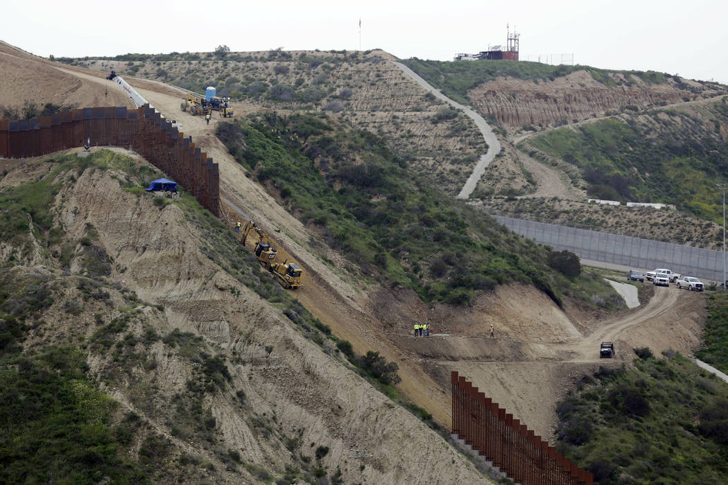 Construction crews replace a section of the primary wall separating San Diego, above right, and Tijuana, Mexico, below left, Monday, March 11, 2019, seen from Tijuana, Mexico. (AP Photo/Gregory Bull)