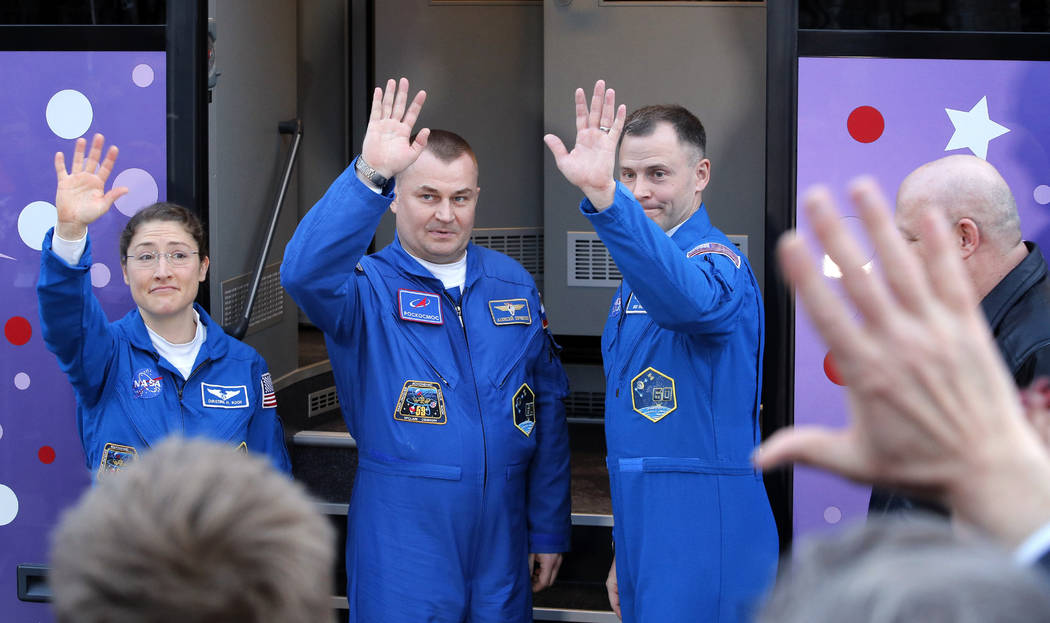 U.S. astronauts Christina Hammock Koch, left, Nick Hague, right, and Russian cosmonaut Alexey Ovchinin, members of the main crew to the International Space Station (ISS), pose near a bus prior to ...