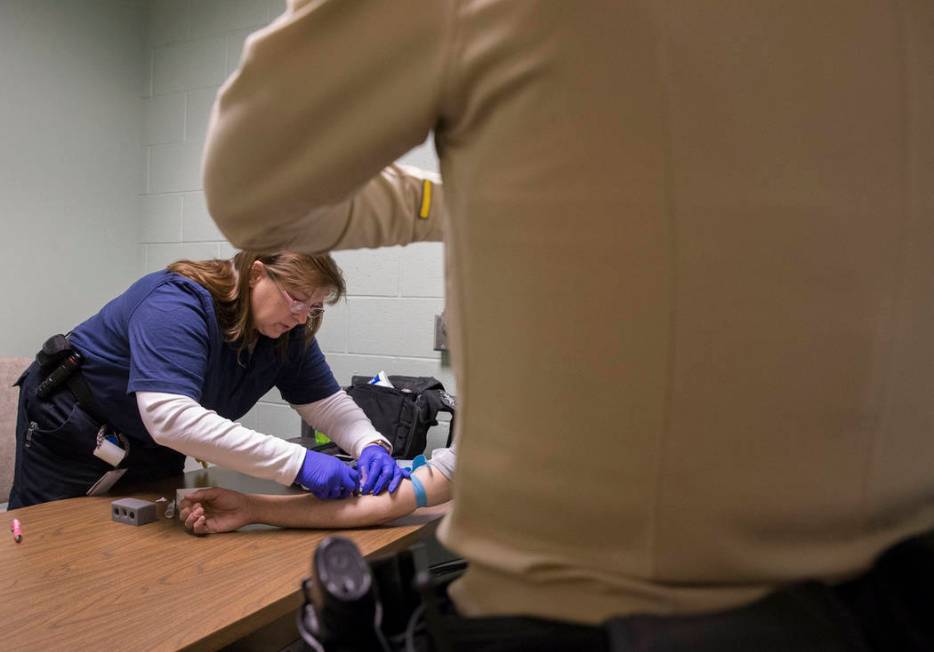 EMT Katharine York, left, draws blood from a suspected impaired driver at the Metro Traffic Bureau as part of a "DUI blitz" on Thursday, March 14, 2019, in Las Vegas. (Benjamin Hager Rev ...