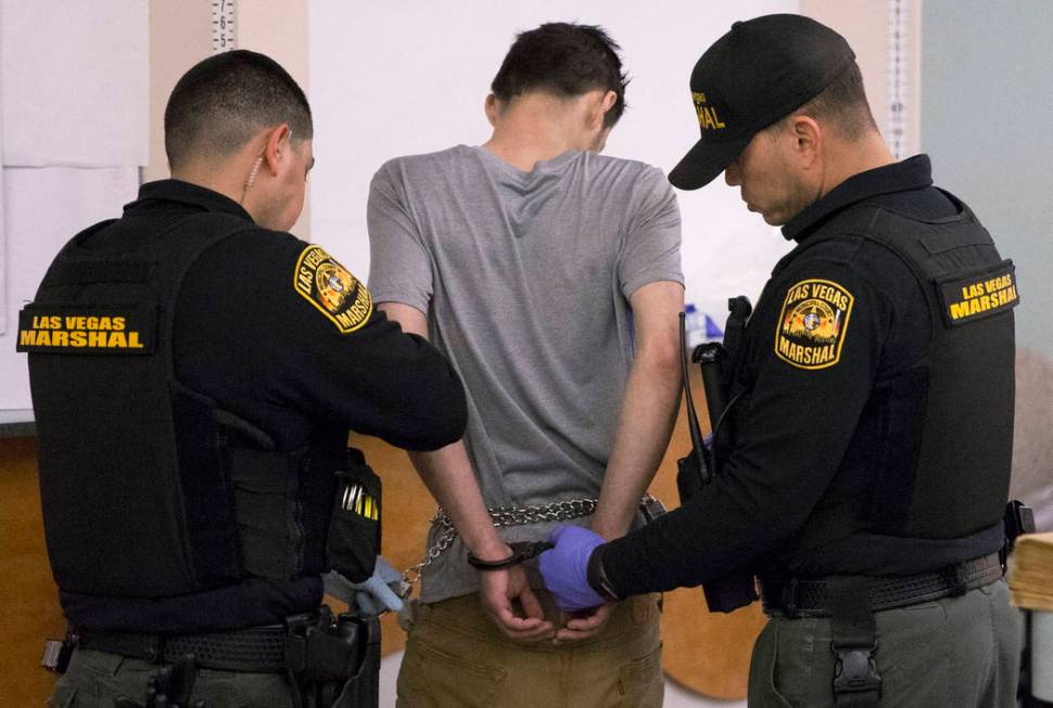 Marshal Johnny Patino, left, and Marshal David Reyes, right, process a suspected impaired driver at the Metro Traffic Bureau as part of a "DUI blitz" on Thursday, March 14, 2019, in Las ...