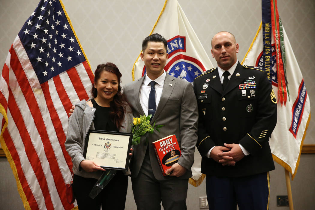 Anthony Hua, center, with his girlfriend Thuy Dihn, left, are photographed with U.S. Army Staff Sgt. Zachary Anderson, a health care recruiter, after getting sworn in as U.S. Army Reserve captain ...