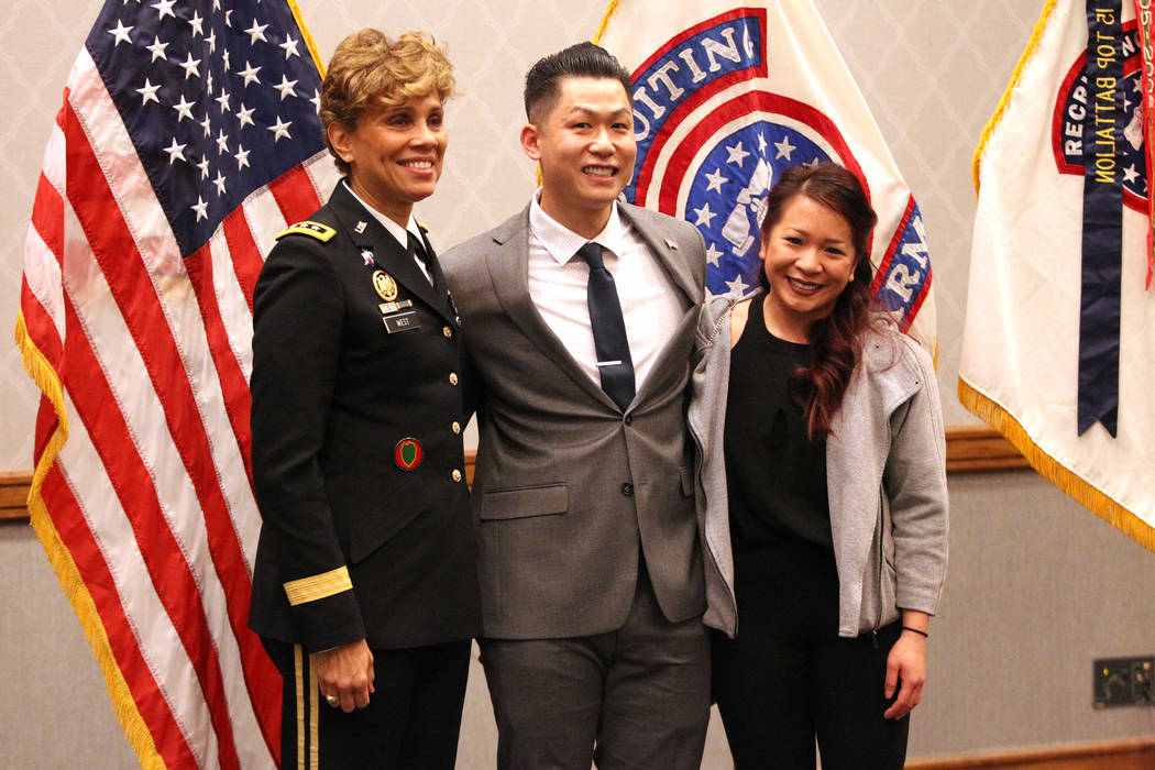 Anthony Hua, center, with his girlfriend Thuy Dihn, right, are photographed with U.S. Army Lt. Gen. Nadja West, after getting sworn in as captain for the U.S. Army Reserve during a ceremony at th ...