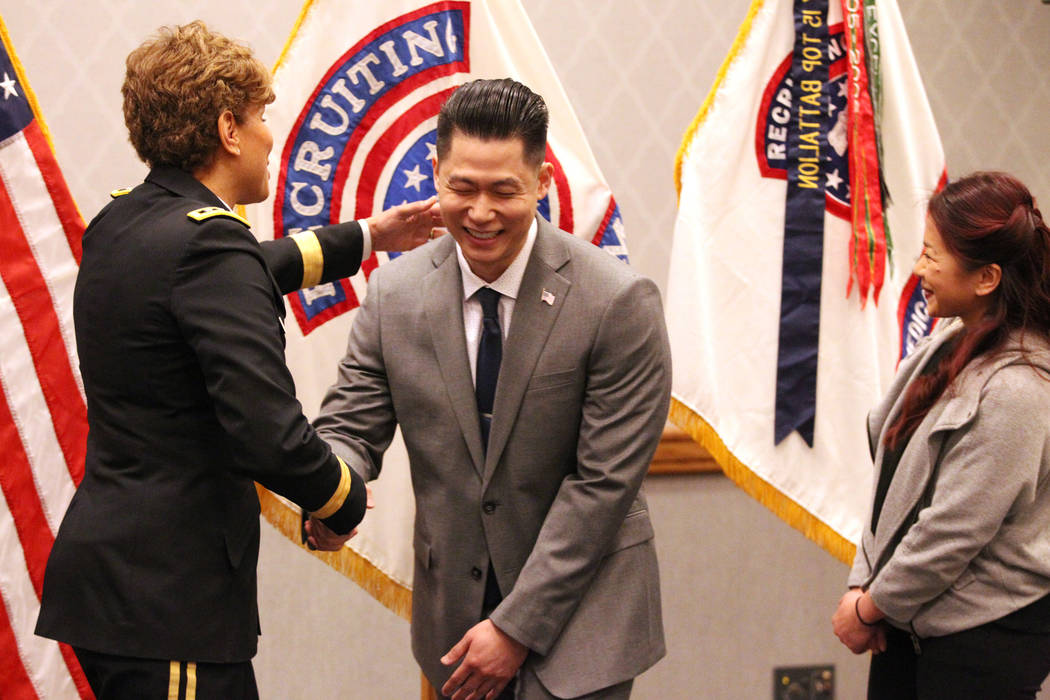 Anthony Hua, center, with U.S. Army Lt. Gen. Nadja West, left, and his girlfriend Thuy Dihn, smiles after getting sworn in as captain for the U.S. Army Reserve during a ceremony at the Hampton Inn ...