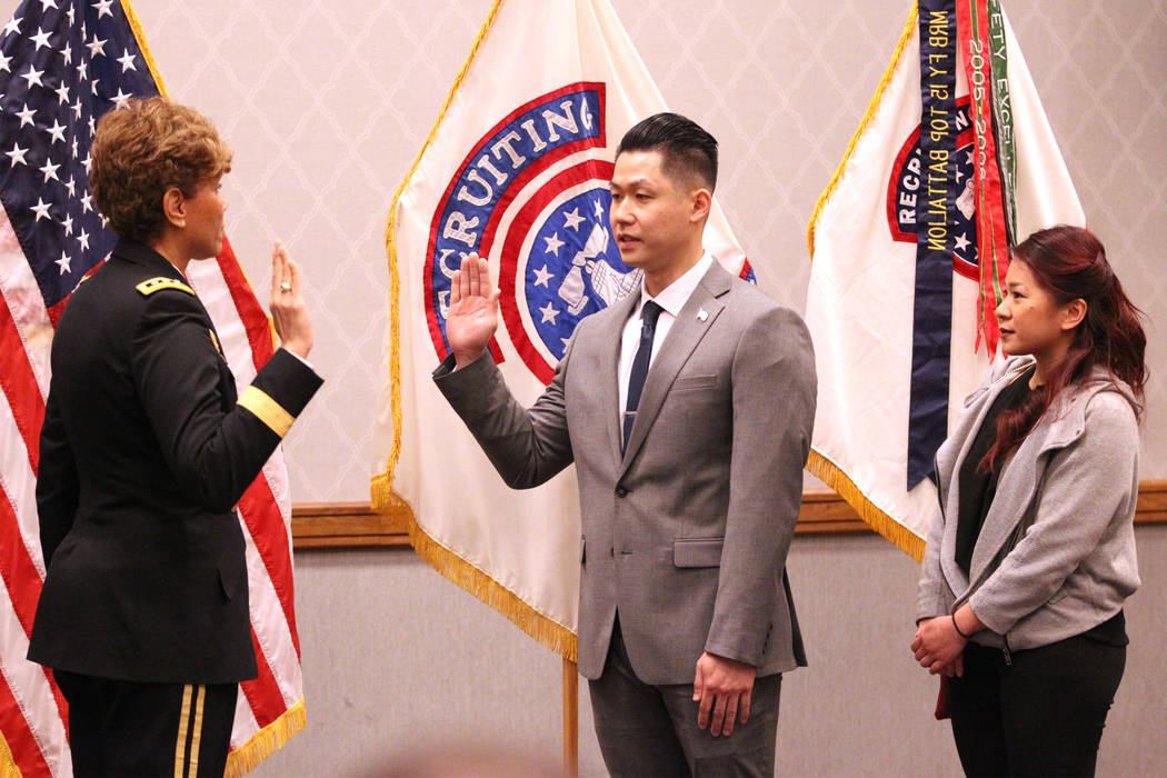 Anthony Hua, center, with U.S. Army Lt. Gen. Nadja West, left, and his girlfriend Thuy Dihn, is sworn in as captain for the U.S. Army Reserve during a ceremony at the Hampton Inn Tropicana and Eve ...