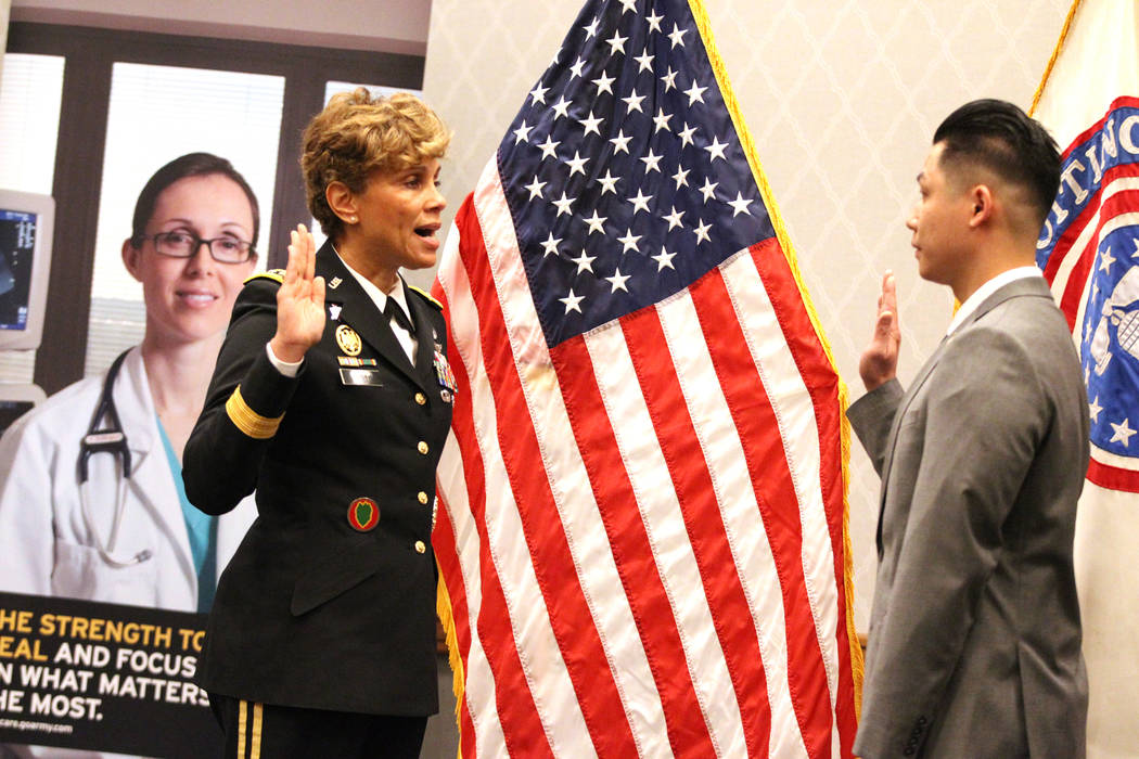 Anthony Hua, right, with U.S. Army Lt. Gen. Nadja West, is sworn in as captain for the U.S. Army Reserve during a ceremony at the Hampton Inn Tropicana and Event Center in Las Vegas, Friday, March ...