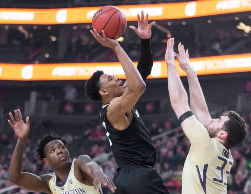 Colorado sophomore guard Tyler Bey (1) drives past Washington sophomore forward Nahziah Carter (11) and junior forward Sam Timmins (33) in the first half during the semifinal game of the Pac-12 t ...
