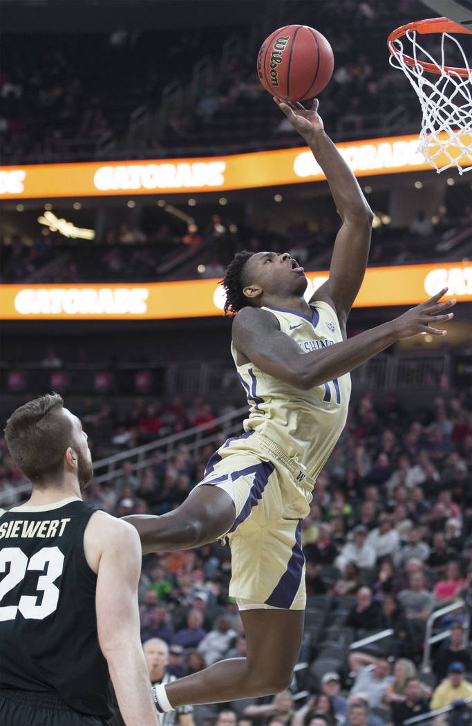 Washington sophomore forward Nahziah Carter (11) drives past Colorado junior forward Lucas Siewert (23) in the second half during the semifinal game of the Pac-12 tournament on Friday, March 15, 2 ...
