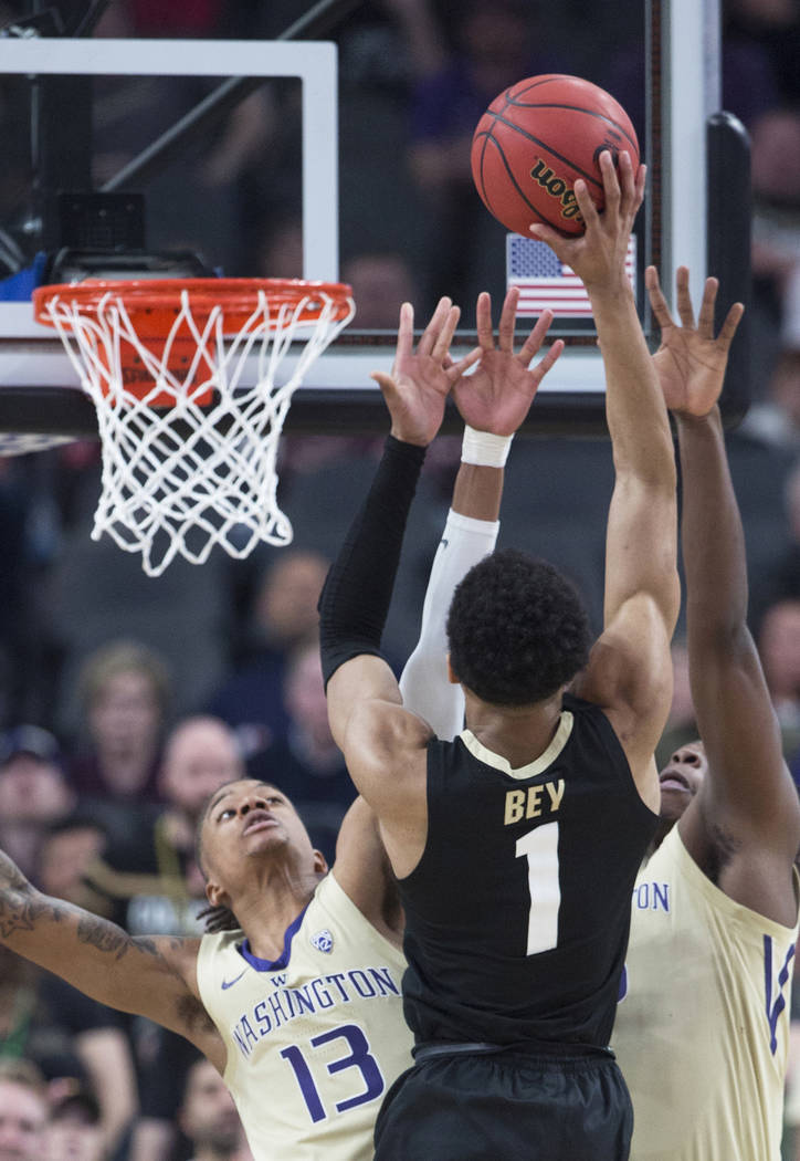 Washington sophomore forward Hameir Wright (13) and sophomore guard Jaylen Nowell (5) reach to block the shot of Colorado sophomore guard Tyler Bey (1) in the second half during the semifinal game ...