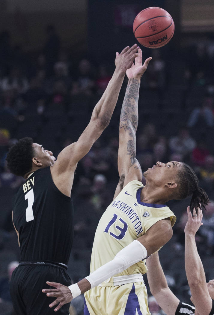 Washington sophomore forward Hameir Wright (13) and Colorado sophomore guard Tyler Bey (1) fight for a loose ball in the second half during the semifinal game of the Pac-12 tournament on Friday, M ...