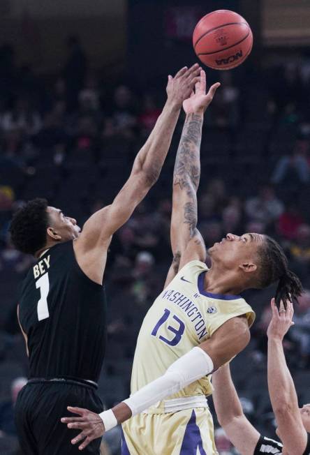 Washington sophomore forward Hameir Wright (13) and Colorado sophomore guard Tyler Bey (1) fight for a loose ball in the second half during the semifinal game of the Pac-12 tournament on Friday, M ...