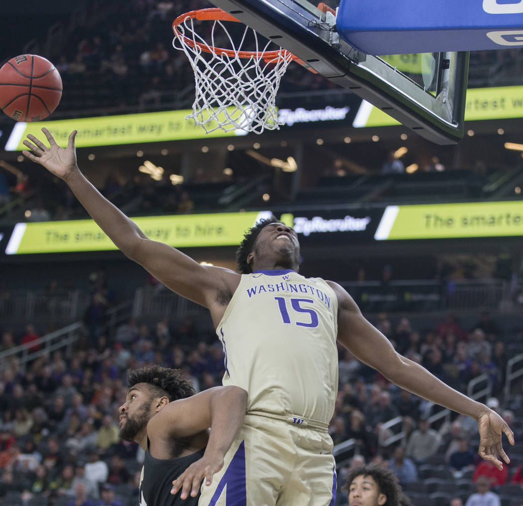 Washington senior forward Noah Dickerson (15) gets pushed by Colorado freshman forward Evan Battey (21) while trying to grab a rebound in the second half during the semifinal game of the Pac-12 to ...