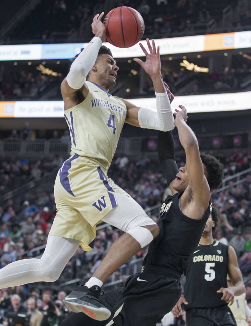 Washington senior guard Matisse Thybulle (4) collides with Colorado junior guard Shane Gatling (0) on the way to the rim in the second half during the semifinal game of the Pac-12 tournament on Fr ...