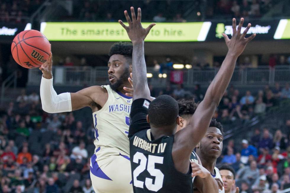 Washington sophomore guard Jaylen Nowell (5) dishes the ball past Colorado sophomore guard McKinley Wright IV (25) in the second half during the semifinal game of the Pac-12 tournament on Friday, ...