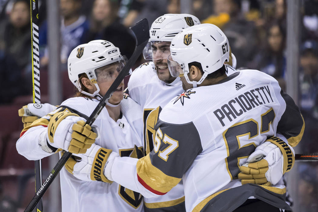 Vegas Golden Knights' Cody Eakin, Alex Tuch and Max Pacioretty, from left, celebrate Pacioretty's second goal against the Vancouver Canucks, during the third period of an NHL hockey game Thursday, ...