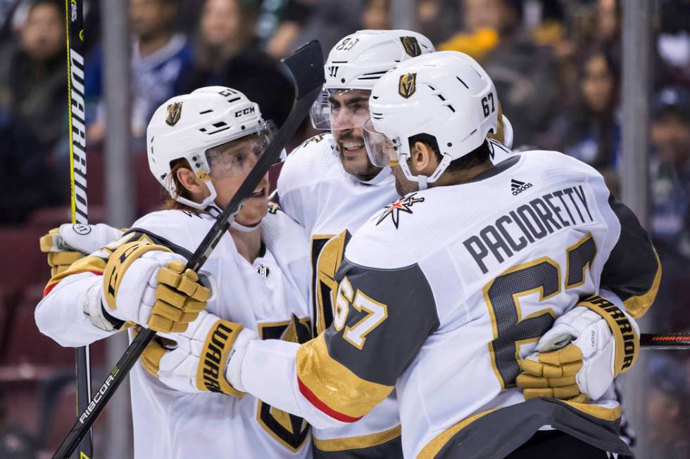 Vegas Golden Knights' Cody Eakin, Alex Tuch and Max Pacioretty, from left, celebrate Pacioretty's second goal against the Vancouver Canucks, during the third period of an NHL hockey game Thursday, ...