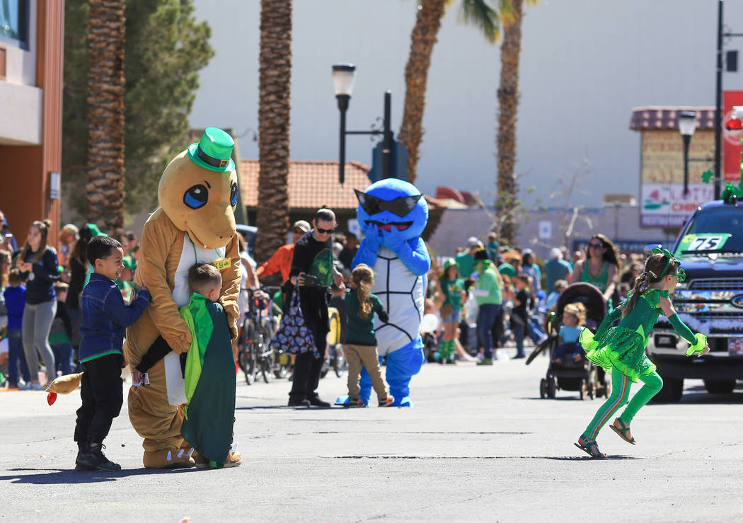 Children run out into the street during the parade to hug Charmander and Squirtel, two Pokemon, in the 53rd Annual Southern Nevada Sons & Daughters of Erin St. Patrick's Day parade in Henderso ...