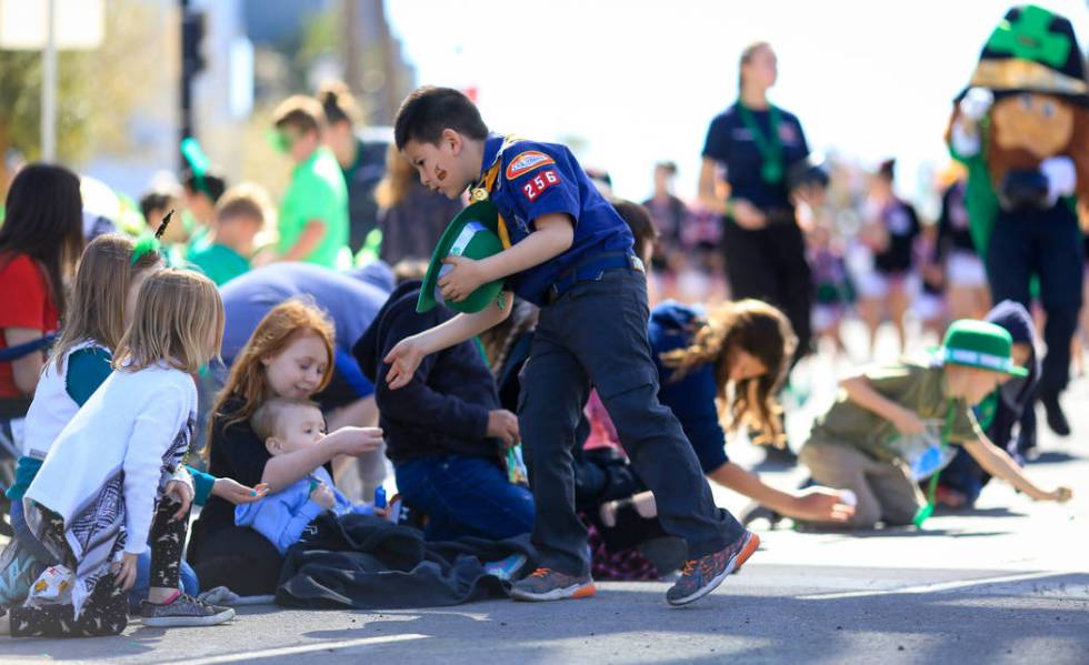 Cub Scout Jayden Riano, center, with Pack 256, lags behind his group as he takes time to make sure each kid gets a piece of candy in the 53rd Annual Southern Nevada Sons & Daughters of Erin St ...