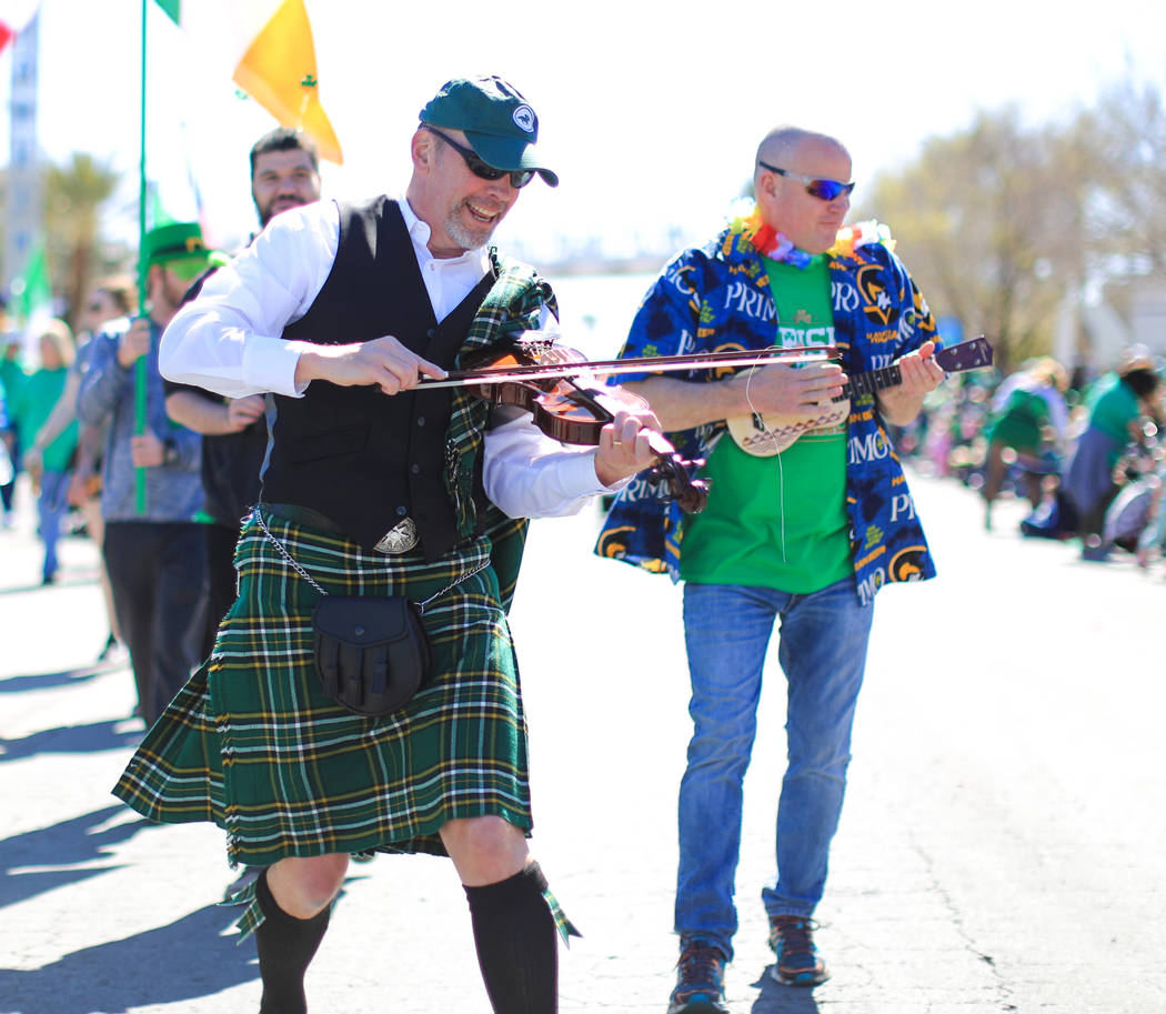 Digger Hawkins, left, and Jeff Bartholomew, right, both with Grape Expectations Nevada School of Winemaking, walk in the 53rd Annual Southern Nevada Sons & Daughters of Erin St. Patrick's Day ...
