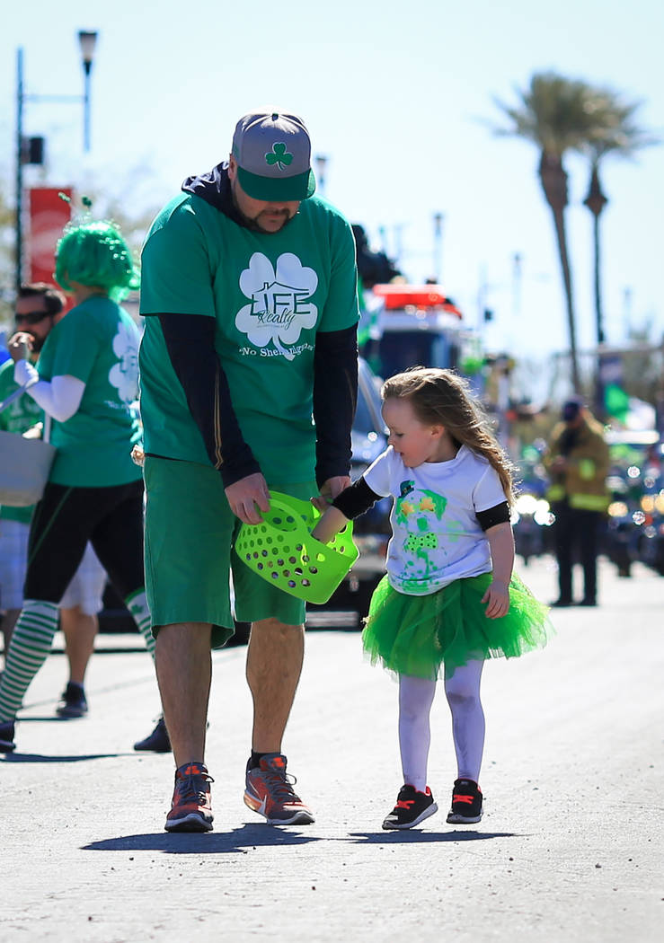 Brooke Leaver gets a refill of candy to throw to parade goers from her dad Bill Leaver, 37, in the 53rd Annual Southern Nevada Sons & Daughters of Erin St. Patrick's Day parade in Henderson, N ...