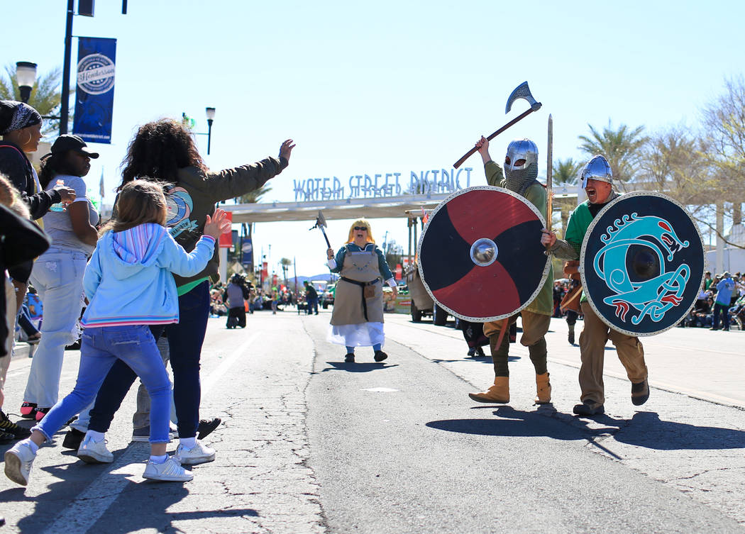 Brian Troxel, far right, and Erik Pappa, center right, with the Sons of Norway, jokingly charge at parade goers lining the streets of the 53rd Annual Southern Nevada Sons & Daughters of Erin S ...