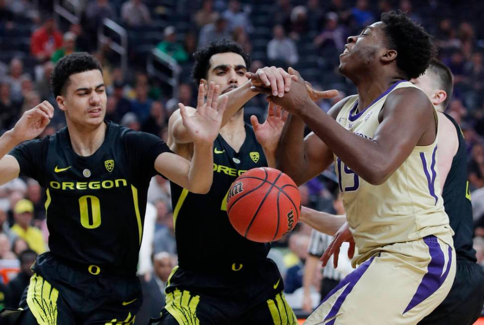 Oregon's Will Richardson, left, and Ehab Amin guard Washington's Noah Dickerson during the first half of an NCAA college basketball game in the final of the Pac-12 men's tournament Saturday, March ...