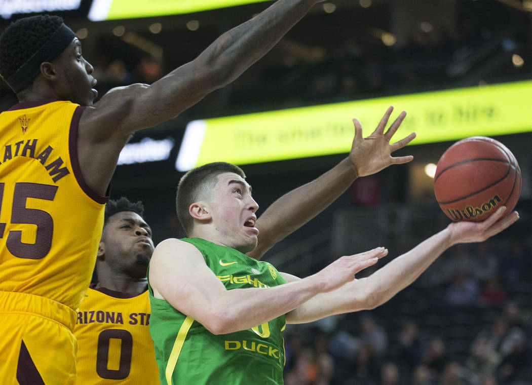 Oregon junior guard Payton Pritchard (3) slices to the rim past Arizona State senior forward Zylan Cheatham (45) and freshman guard Luguentz Dort (0) in the second half during the semifinal game o ...
