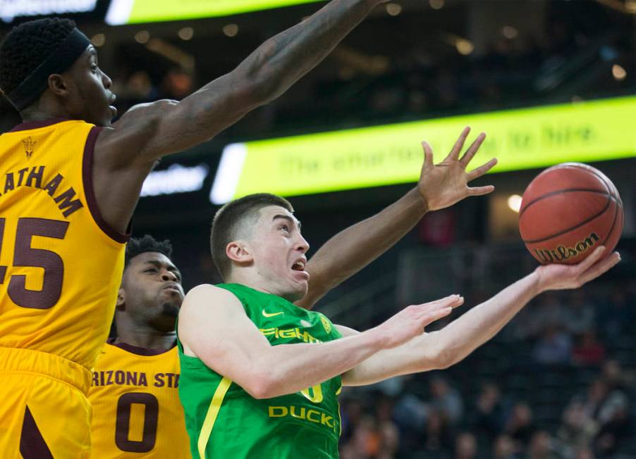 Oregon junior guard Payton Pritchard (3) slices to the rim past Arizona State senior forward Zylan Cheatham (45) and freshman guard Luguentz Dort (0) in the second half during the semifinal game o ...