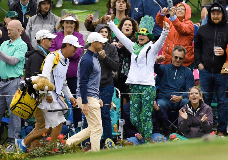 Rory McIlroy, of Northern Ireland, walks past cheering spectators on his way to the 17th green Sunday afternoon during the final round of The Players Championship golf tournament Sunday, March 17, ...