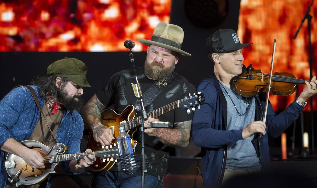 Coy Bowles, from left, Zac Brown and Jimmy De Martini of the Zac Brown Band perform at Fenway Park on Friday, June 15, 2018, in Boston. (Photo by Winslow Townson/Invision/AP)