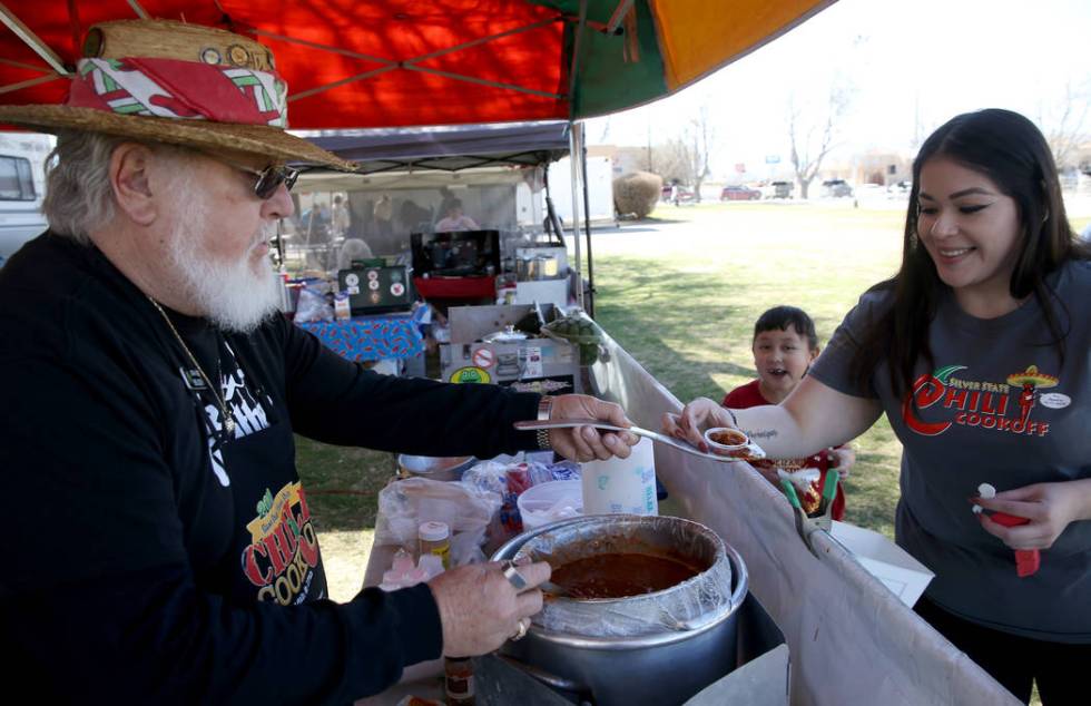 Mike Austin of San Bernardino, California, offers his People's Choice chili to Josie Kuezado and her daughter Alaiyah Brooks, 6, of Pahrump in his booth at the Nevada State Chili Cook-off at Petra ...