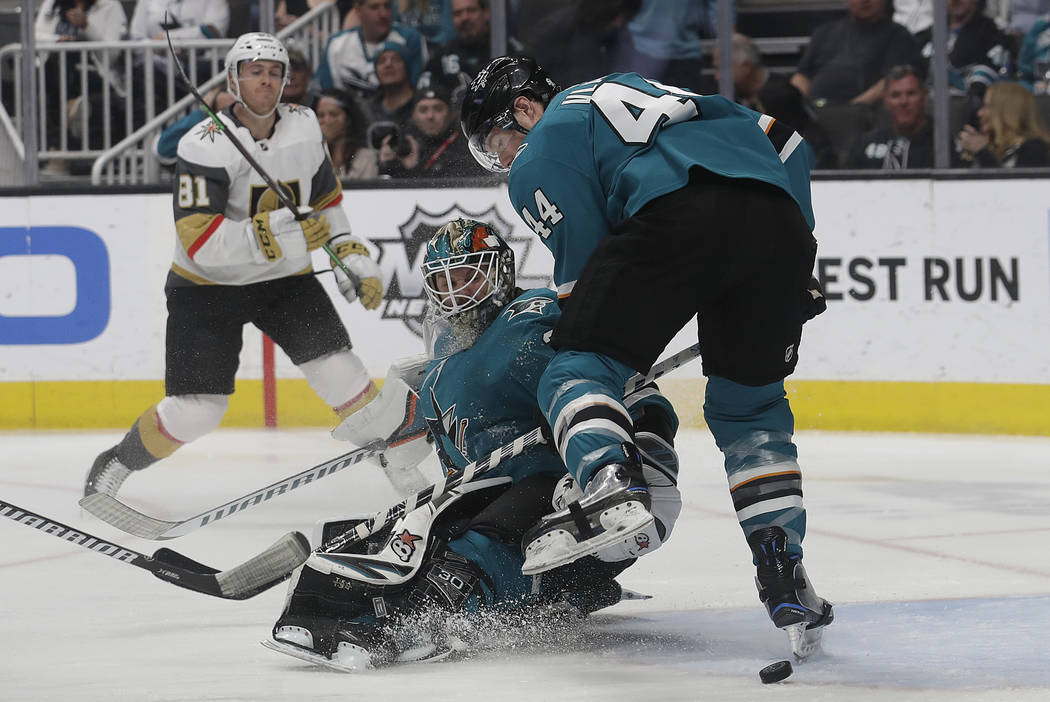 San Jose Sharks goaltender Aaron Dell, center, and defenseman Marc-Edouard Vlasic (44) look for the puck in front of Vegas Golden Knights center Jonathan Marchessault (81) during the second period ...