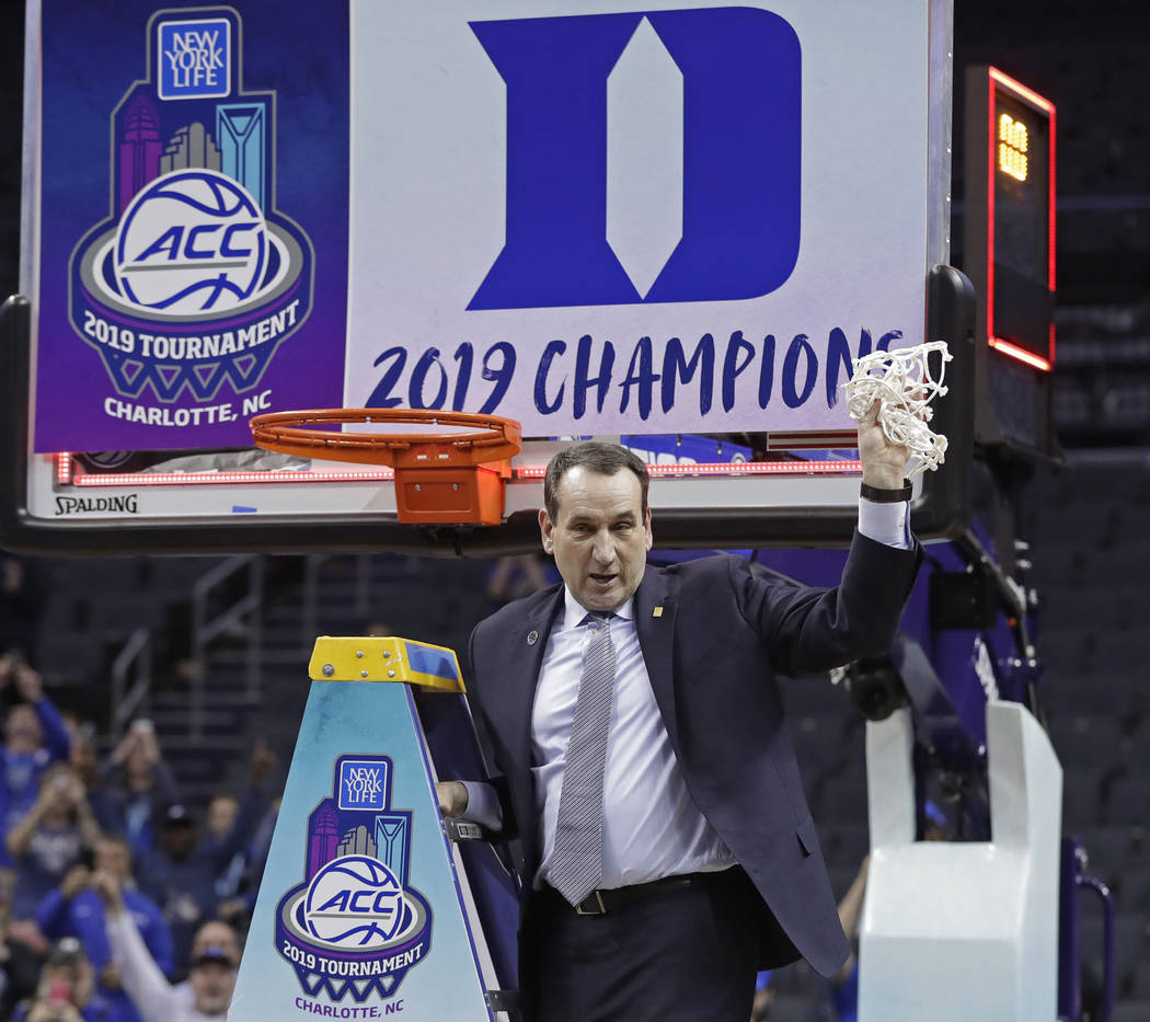 Duke head coach Mike Krzyzewski celebrates Duke's win over Florida State after cutting down a net after the NCAA college basketball championship game of the Atlantic Coast Conference tournament in ...