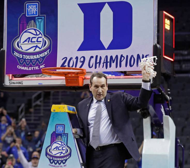 Duke head coach Mike Krzyzewski celebrates Duke's win over Florida State after cutting down a net after the NCAA college basketball championship game of the Atlantic Coast Conference tournament in ...